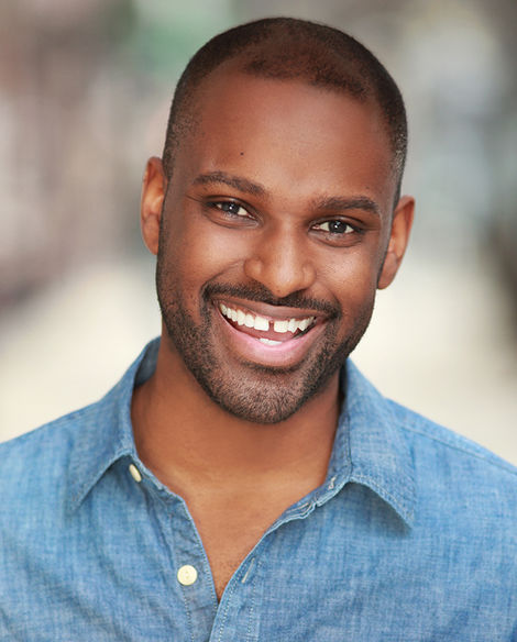 Actor headshot of handsome man in denim shirt shot outside on location in natural light with blurred background in Brooklyn, New York