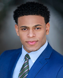 Professional headshot of black man wearing blue suit shot outdoors in natural light in NYC