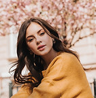 brunette-woman-stylish-sweater-looks-camera-against-background-sakura-lady-yellow-outfit-p