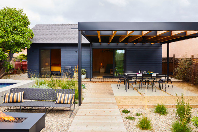 a modern blue and black accessory dwelling unit with hardscaping and outdoor seating
