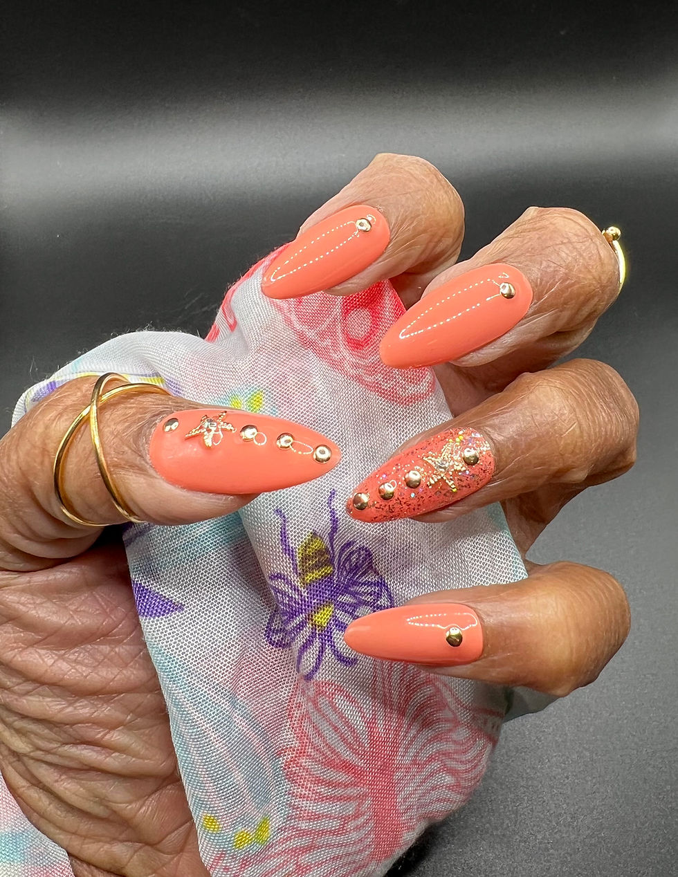 Almond shaped press-on nails, peach colored with rhinestones on a hand