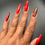 Thumbnail: long coffin shaped, press-on nails, red colored with designs on a hand
