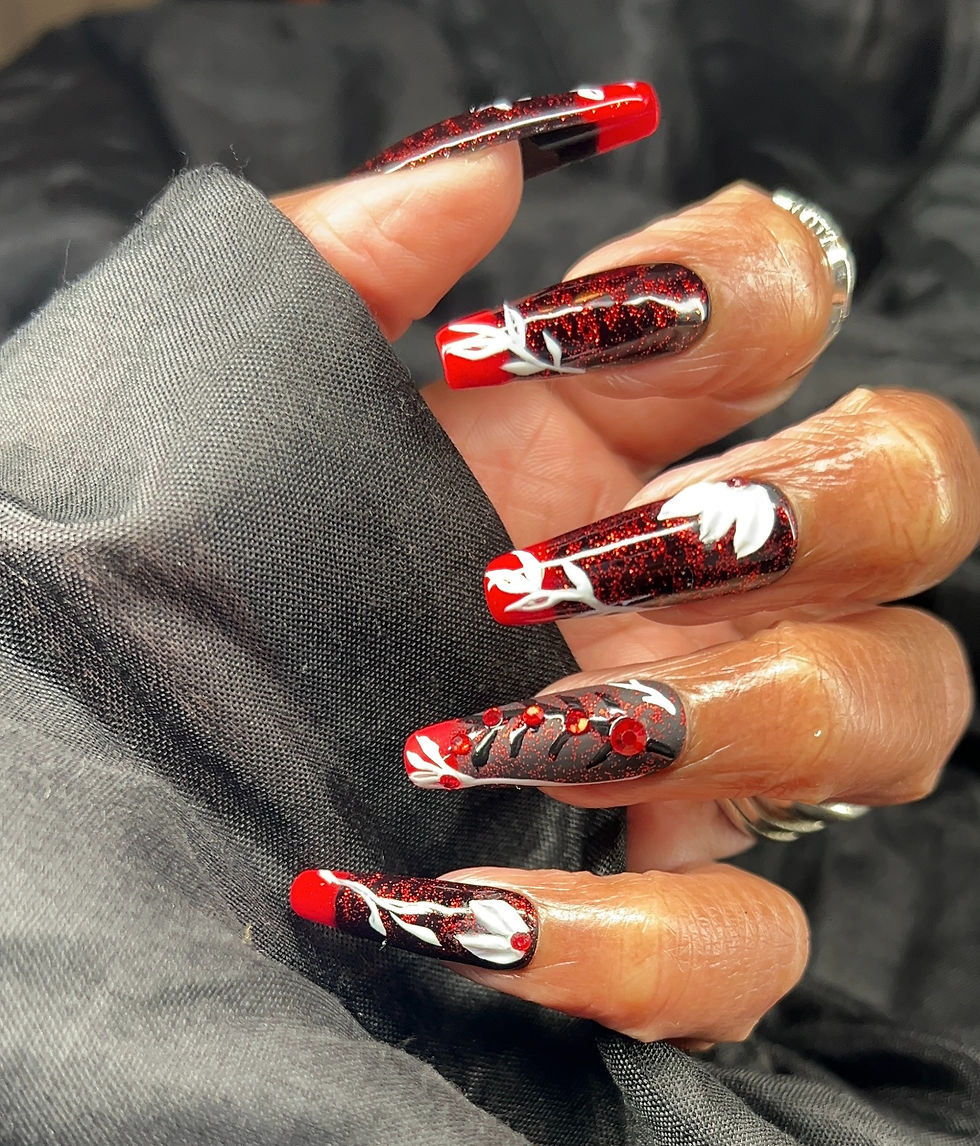 Press-on nails in black, red and white floral designs on a hand