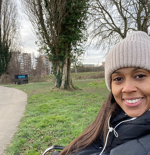 Bianca Clarke, psychotherpaist sitting on a bench for wellness with autoimmunity