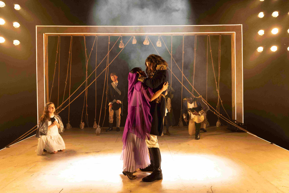 A production photo of two actors in a close embrace