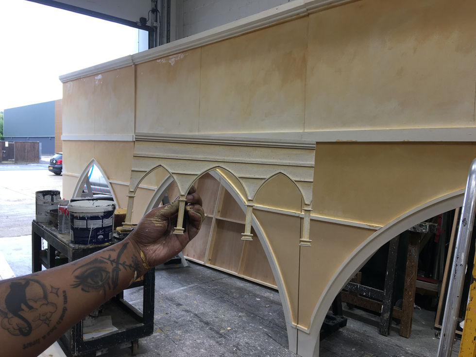 A photo of a model piece next to the finished to-scale piece.