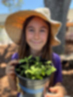 Student smiles with potted herbs