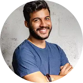 Smiling man with a beard wearing a blue shirt, looking at the camera.