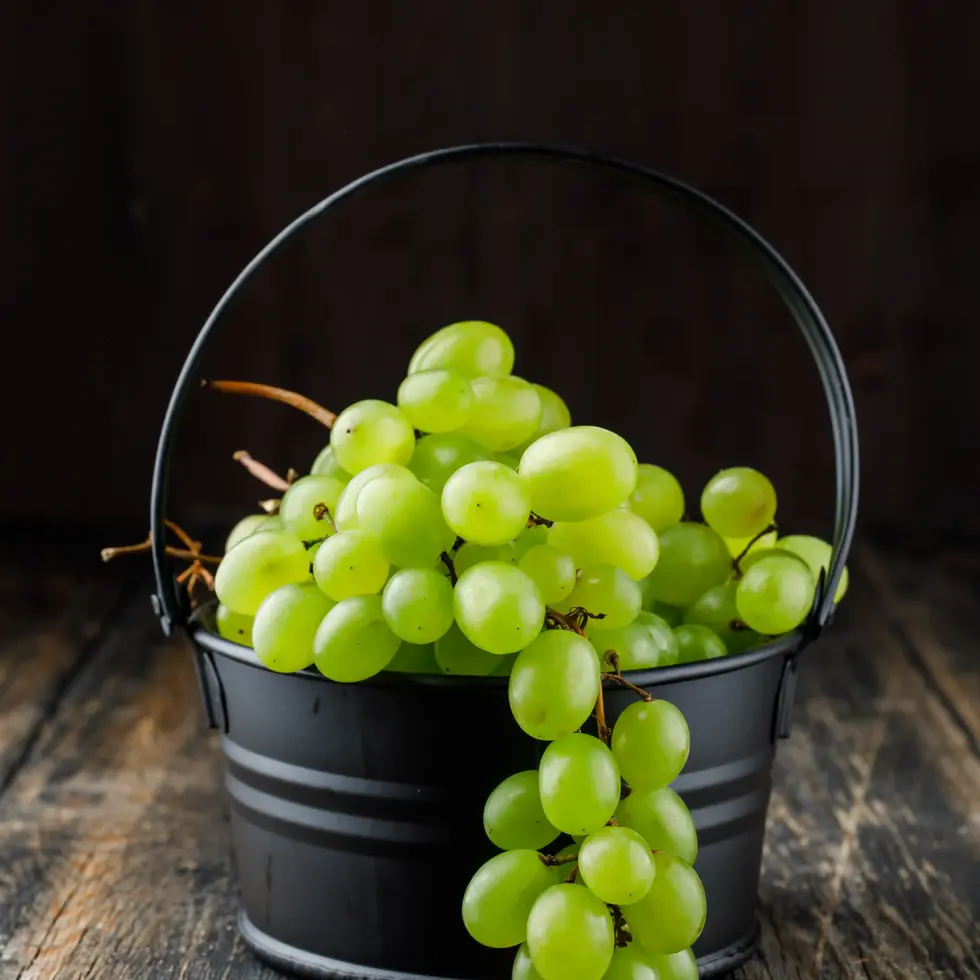Green grapes in a black bucket