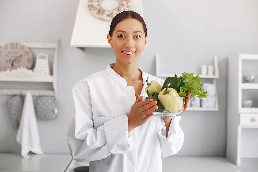 Smiling chef holding a bowl of fresh bell peppers.