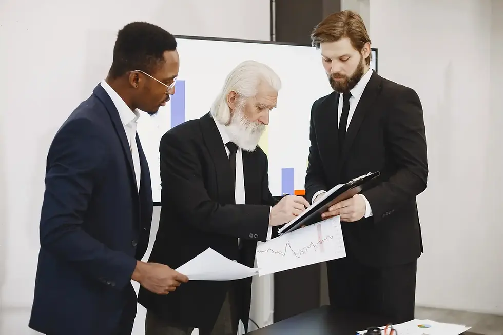 Three businessmen reviewing documents and charts