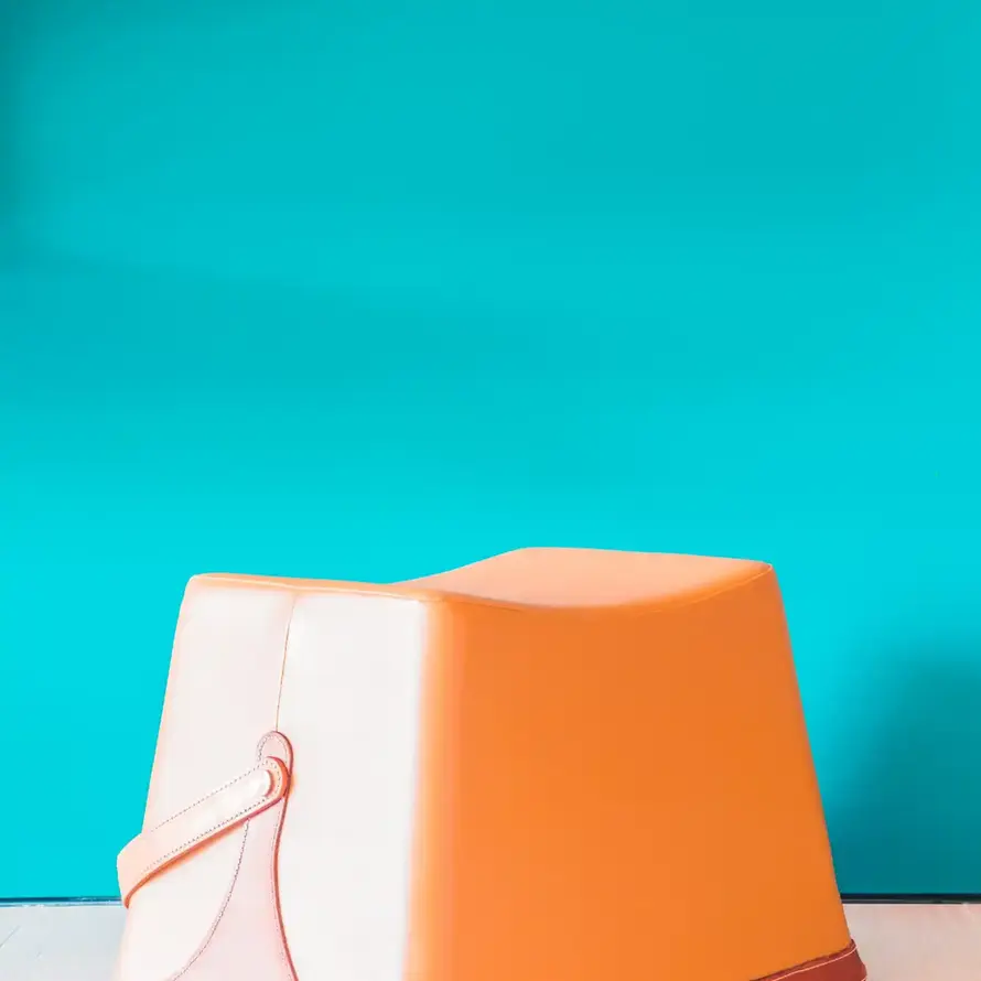 Peach-colored plastic potty chair against teal wall