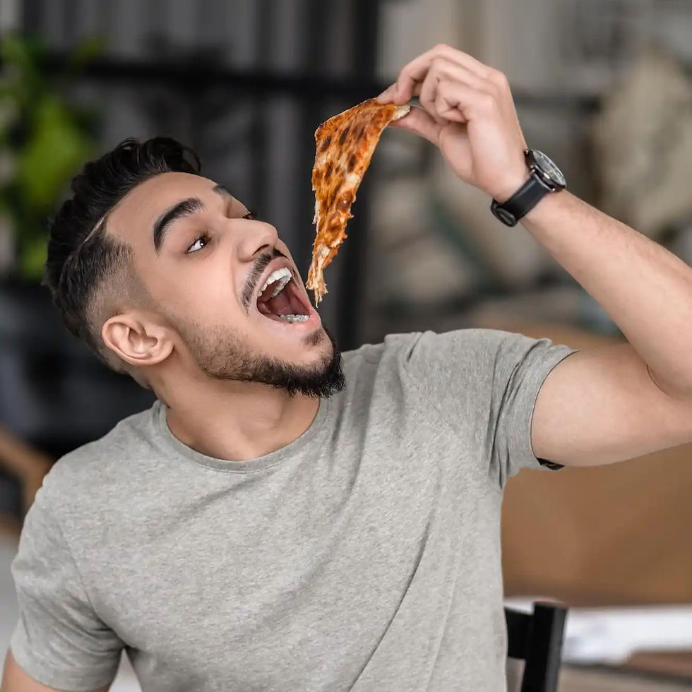 Enthusiastic young man about to enjoy a cheesy pizza slice.