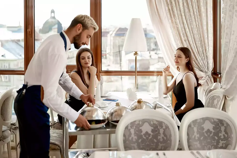 Waiter serving elegant diners at upscale restaurant
