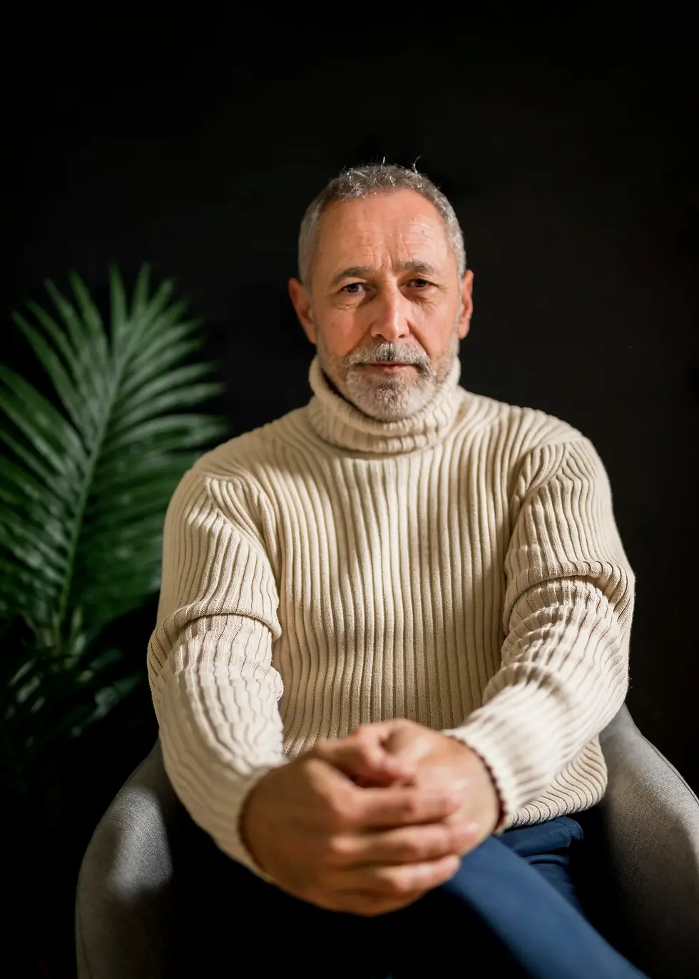 Portrait of elderly man in cream turtleneck