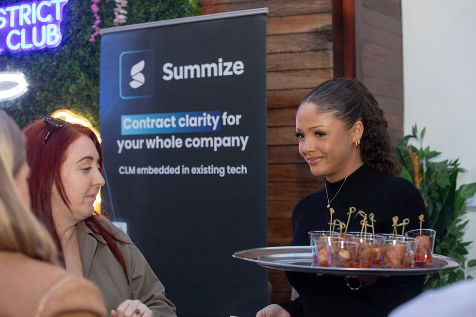 Professional networking mixer at Joy District rooftop in Chicago with sponsor signage and catered appetizers photographed by Walking Visions Photography.