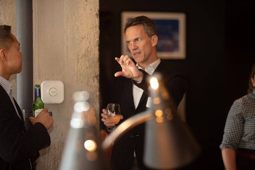 Close-up candid conversation between professionals at Chicago networking event with ambient lighting details
