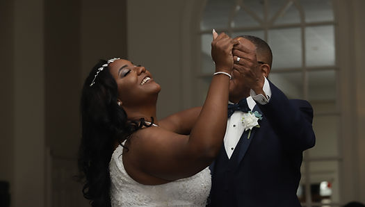 Bride and her father holding hands mid-dance during the father-daughter wedding reception moment.