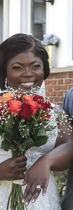 Bride and groom laughing together after the wedding ceremony, holding a bouquet and celebrating their newly exchanged rings.