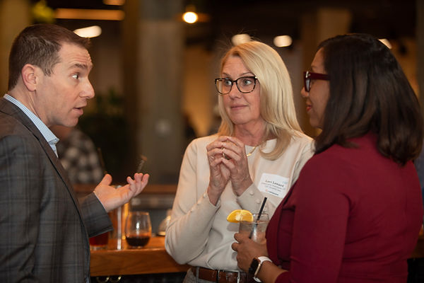 Professionals networking and having a conversation during a corporate mixer event at Marshall's Landing inside the Merchandise Mart captured by Walking Visions Photography.