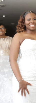 Beautiful bridal portrait at Manzo’s Banquets & Catering in Chicago featuring bride in strapless lace wedding gown smiling in soft natural light with mother blurred in background