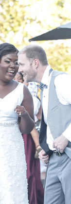 Candid moment of the bride and groom whispering jokes to each other during their wedding reception, captured in a natural documentary wedding photography style.