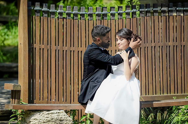 Groom gently caressing the bride’s hair as they share an intimate moment in front of tall brown gates during their Chicago we