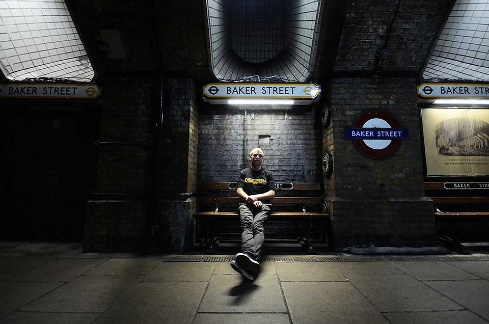 man sitting on platform bench at Baker Street in London in 2013