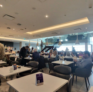 Crowded No1 Lounge Birmingham Airport seating and dining area with passengers waiting for tables