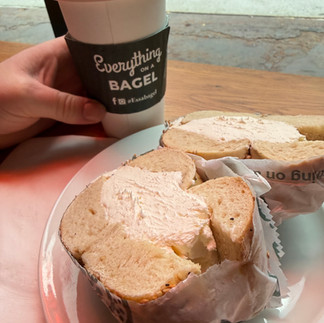 Fresh New York bagel with cream cheese on brown paper, classic Brooklyn breakfast