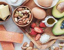 Assorted healthy foods including salmon, eggs, avocado, and nuts representing meal prep and nutrition services on the FIT30A Health and Wellness page.