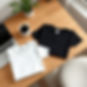 Create a clean, photorealistic workspace scene featuring two folded T-shirts placed neatly