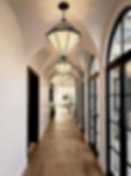 Modern hallway design by LINEN + ORCHID with hardwood flooring, statement lighting and metal french doors.