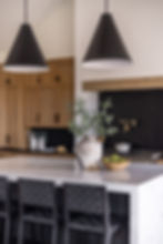 Mid-Century kitchen design by LINEN + ORCHID with a quartz island and large black statement pendant lighting