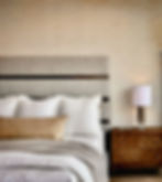 Upholstered bed with night stand and table lamp with textured wall paper designed by LINEN + ORCHID