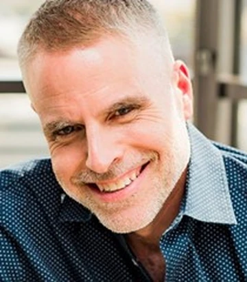man in blue button-down shirt smiling
