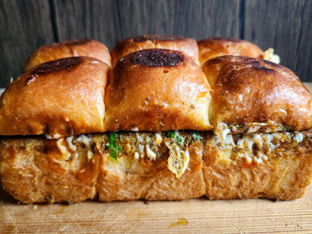 Close-up of the egg mixture being whisked with minced lamb and spices in a shallow bowl.