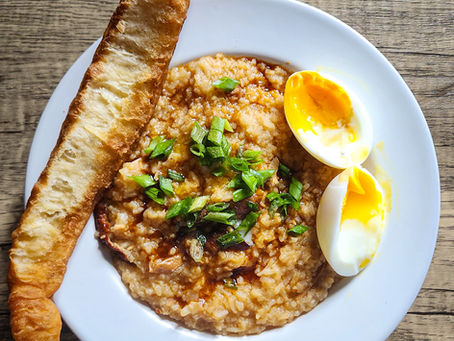 Chicken congee made from leftover chicken rice and nasi lemak with shredded roasted chicken, topped with a soft-boiled egg, crispy you tiao, dark soy sauce and chopped scallions.