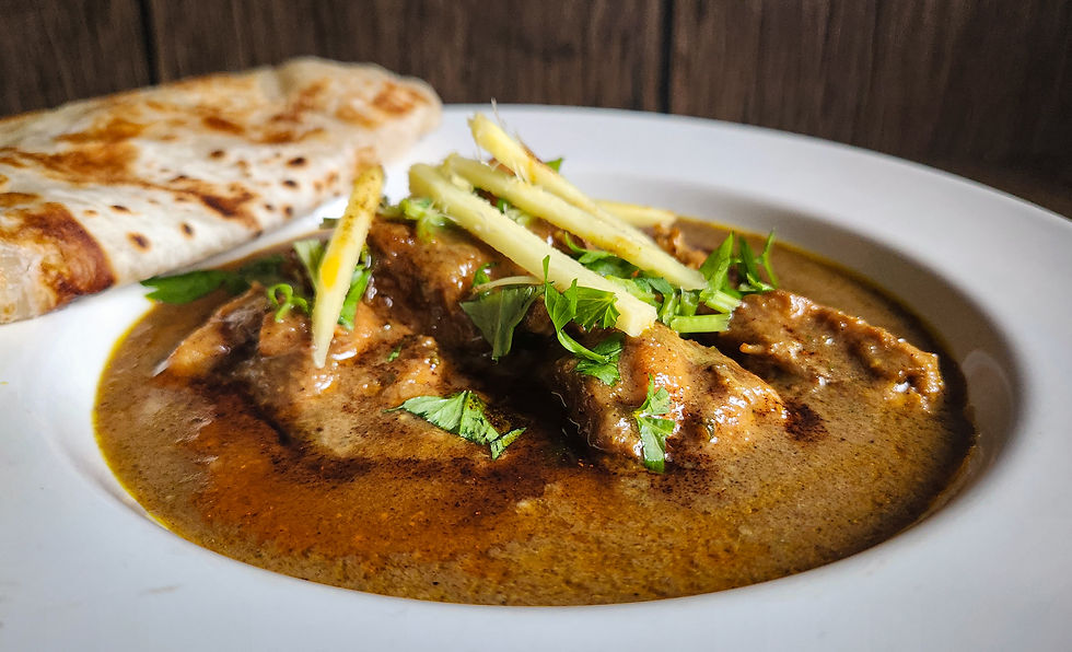 Side view of plated nihari garnished with julienned ginger and coriander.