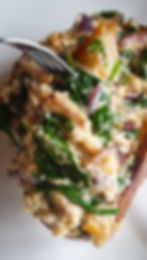 Fork lifting a bite of creamy spinach and onions from the toast.