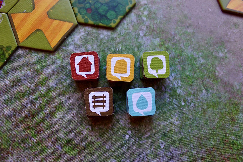 Game tiles in different colors with symbols matching the five terrain types