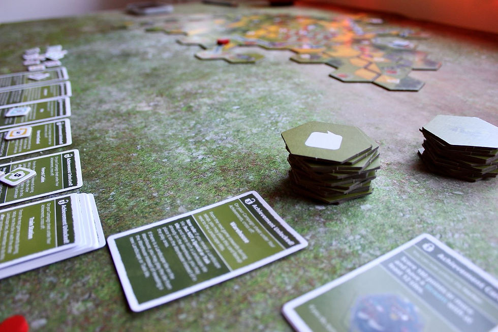 game components are spread across a table with arranged hexagonal tiles in the background