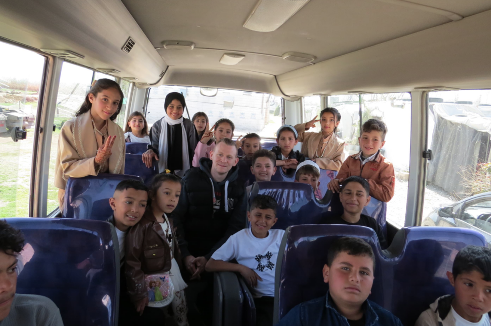 Sebastian and the children from the refugee camp are traveling by bus.