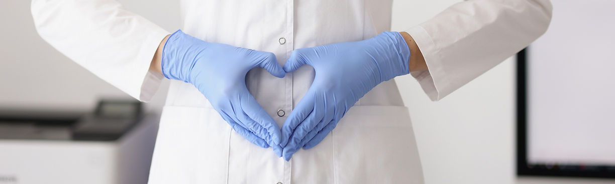 artist in white coat, holding hands in shape of a love heart