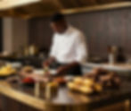 Chef africain talentueux dressant un plat en cuisine.