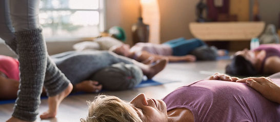 Women laying supported corpse pose in restorative yoga_edited.jpg