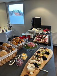 Aufgebautes Frühstücks-Catering mit Brötchen, Käseplatte, Wurstplatte usw.