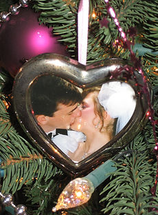 A photo of Soquel and her husband Grant in their wedding clothes kissing. It's in a heart shaped frame hung on the Christmas tree.