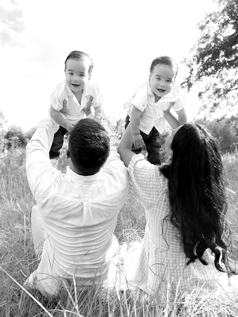 Twin boys being held up in the air by mom and dad during a gorgeous family session.