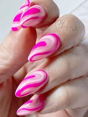 mond-shaped nail extensions with a pink-on-pink swirl design. Vibrant nail art with glossy finish featuring light and hot pink swirls. Trendy nail extensions for bold and eye-catching manicure.
